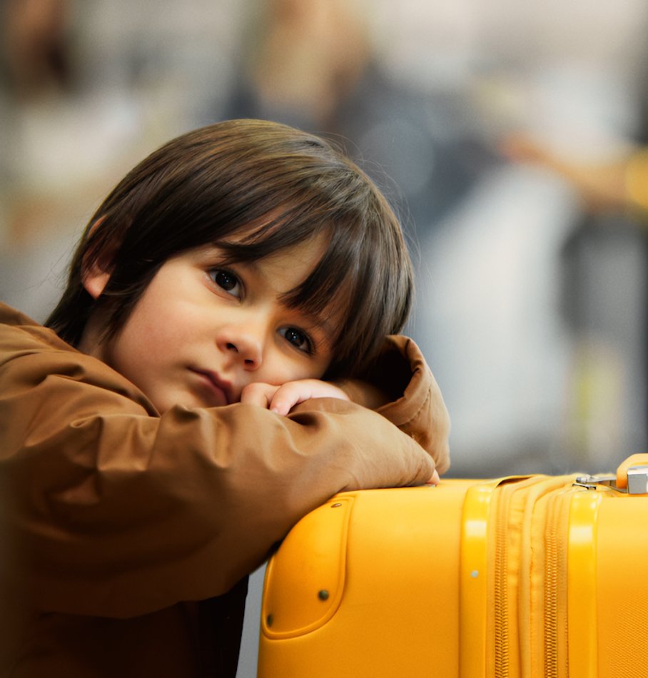 Kid leaning on yellow suitcase