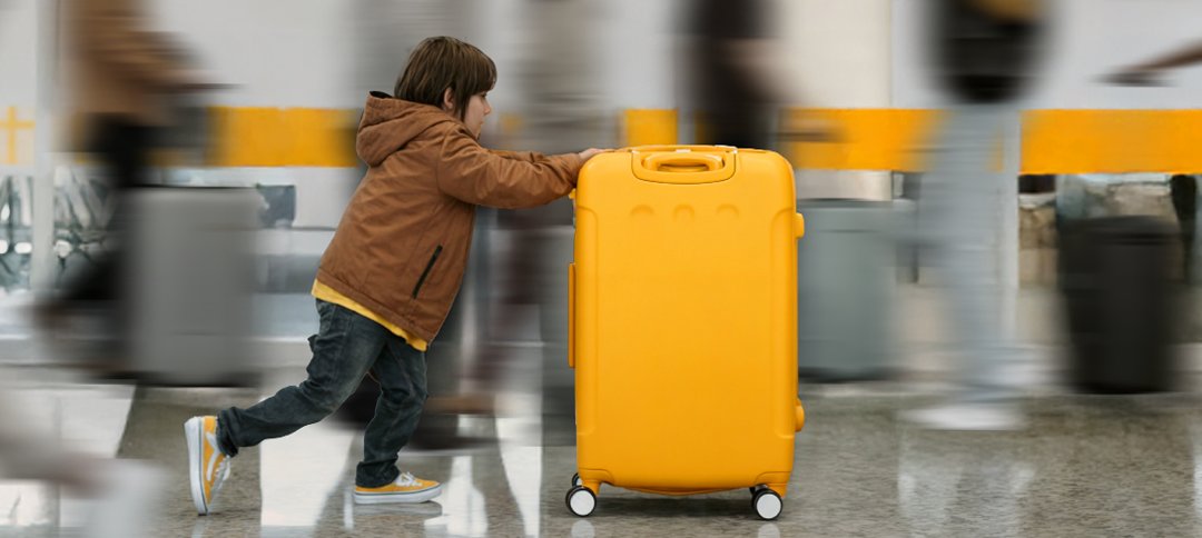 Kid pushing yellow suitcase