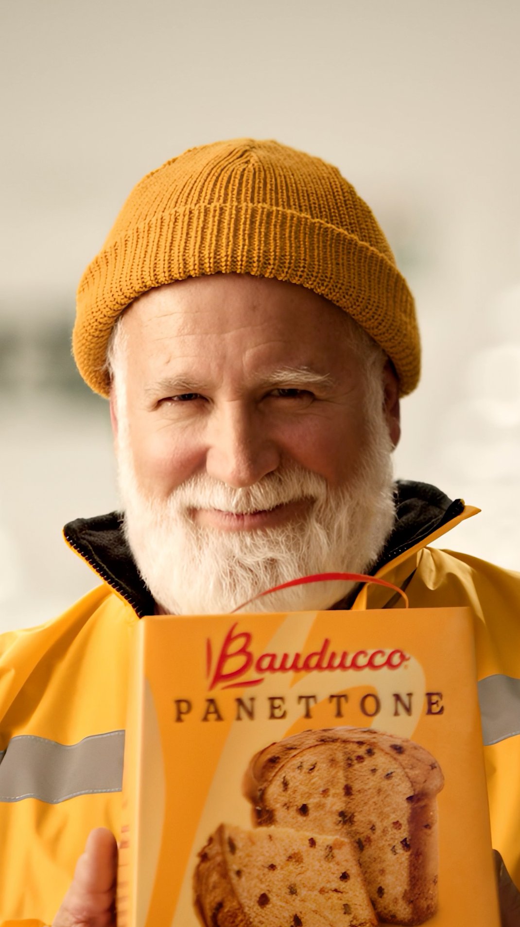 Man in yellow beanie holding panettone